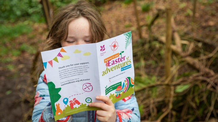 A girl reading her Easter trail activity sheet